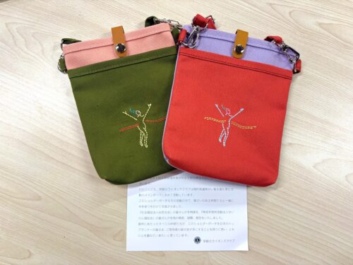 北ライオンズクラブより贈呈の記念品の写真(フィニッシュテープを切るランナーのイラストが刺繍された緑とピンク、または赤と薄紫のポシェット)